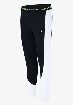 Colanți alb-negru cu un design sportiv, având un tiv cu logo verde și un mic logo negru pe față, confecționați dintr-un material elastic.