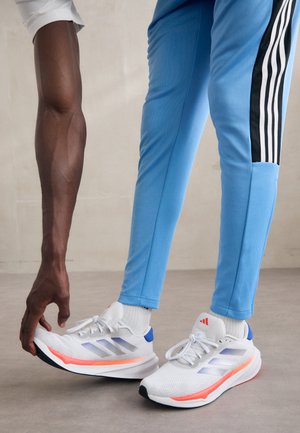 SUPERNOVA STRIDE - Zapatillas running asfalto - footwear white/team royal blue/solar red