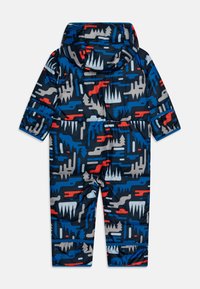 Combinaison de neige rembourrée pour bébé en bleu marine, dotée de motifs abstraits rouges, gris et bleus. Comprend une capuche et des poignets élastiques pour plus de chaleur.
