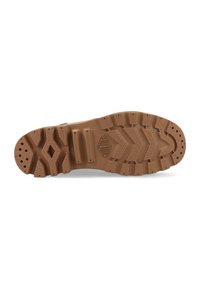 Suola di scarpa in gomma marrone chiaro con un motivo di battistrada testurizzato, caratterizzata da scanalature e tasselli per la presa, e un dettaglio del logo centrale.