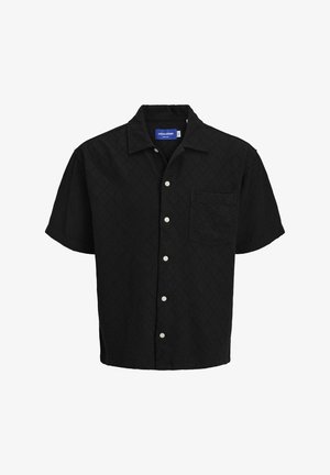 Lühikeste varrukatega must särk, tekstureeritud kangas teemantmustriga, nööpidega ees, ühe rinna taskuga ja valged nööd.