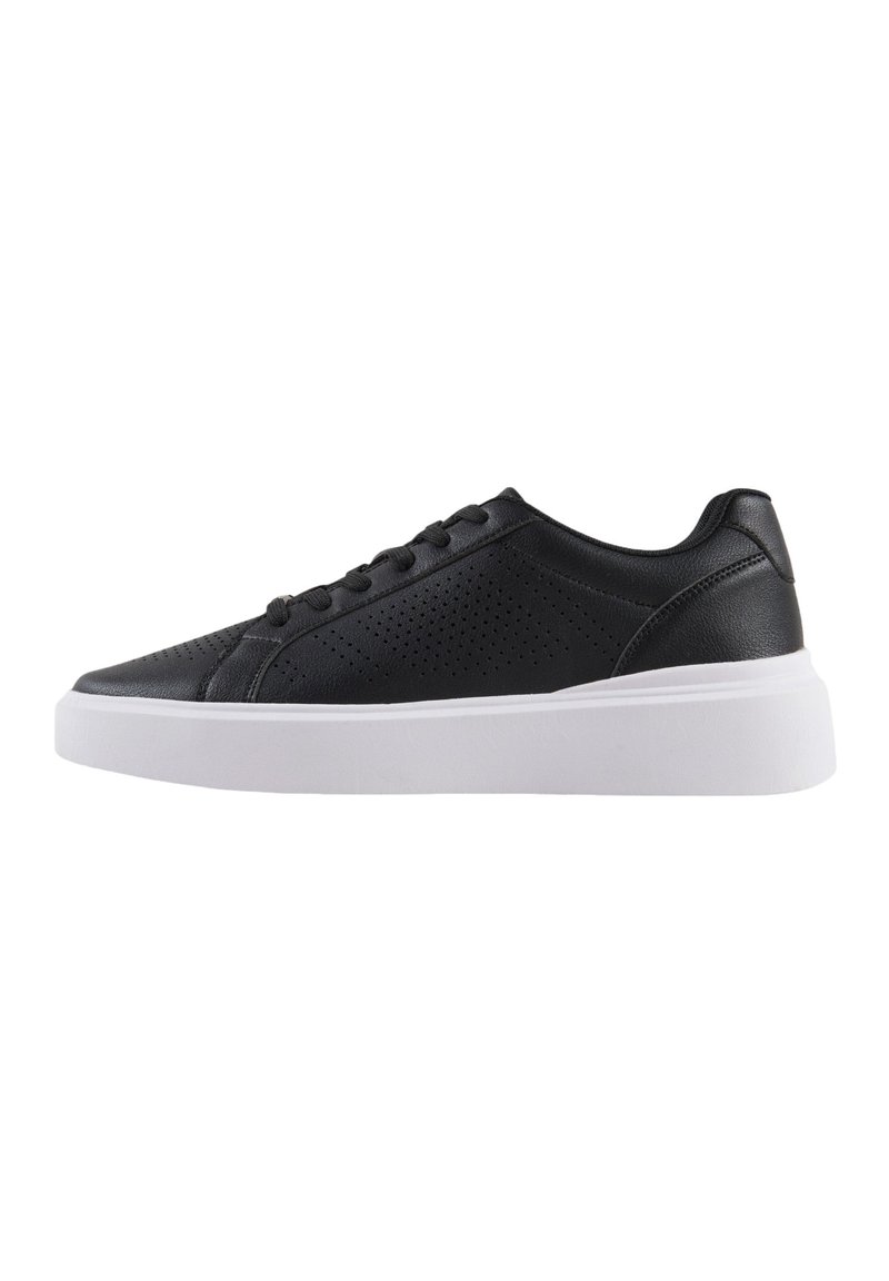 Zapatillas de cuero negro con detalles perforados, suela blanca plana y seis pares de ojales para los cordones. Diseño clásico de corte bajo.