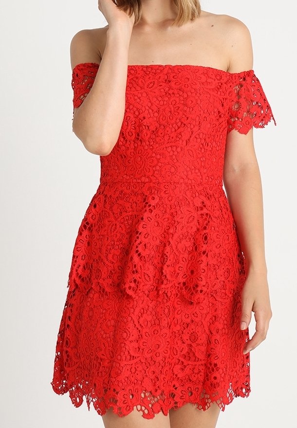 Robe rouge épaules dénudées en dentelle, ornée de motifs floraux, avec un corsage ajusté et une jupe évasée à ourlet festonné.