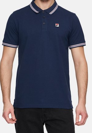 Granatowa krótkorękawowa koszulka polo z białym i czerwonym paskowanym kołnierzykiem oraz rękawami, z małą naszywką z logo na lewej piersi.