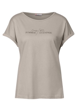 T-shirt beige à manches courtes en tissu doux, avec un design imprimé comportant le texte "Soirées d'été confortables" en marron foncé.