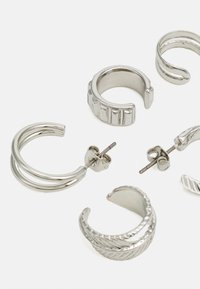 Pendientes de aro de plata en varios diseños, con texturas lisas, estriadas y retorcidas, con cierres de tuerca y de clip.