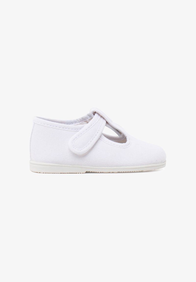 Chaussure Mary Jane en toile blanche avec un bout rond, une bride sur le dessus du pied et une semelle en caoutchouc. Texture lisse et design minimaliste.