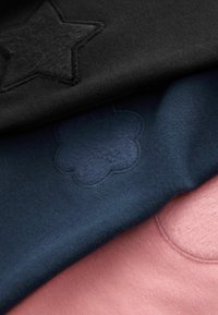 Drei Stoffschichten: schwarz mit einem Sternmuster, marineblau mit einem Wolkenmuster und zartrosa, alle mit einer glatten Textur.
