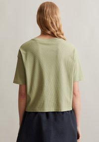 Korte mouwen cropped t-shirt in lichtgroen, gemaakt van ribbelstof. Heeft een ronde halslijn en een rechte zoom op de taille.