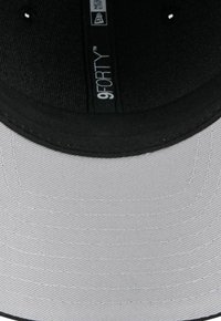 Schwarze und graue Kappe mit strukturierter Krone und flachem Schirm. Hergestellt aus Stoff mit sichtbaren Nähten und einem Logo-Aufkleber im Inneren.