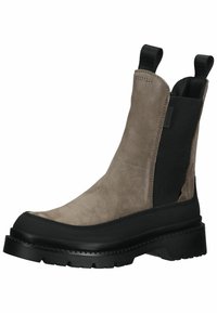 Suede chelsea boot in light brown with black elastic side panels and a thick black rubber sole, featuring a textured finish and pull tabs.