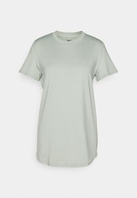Camiseta Nike verde claro, de manga corta, con cuello redondo, textura suave, corte relajado, etiqueta visible en el interior del cuello.