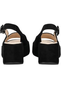 Chaussures à talon bloc en suède noir avec une bride de cheville, présentant un bout arrondi et une doublure intérieure lisse. Pas de motifs visibles ni de détails matériels.