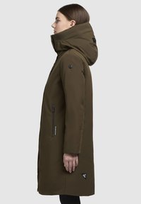 Olivengrønt parka-jakke med høj krave, hætte og lynlåslommer i siderne. Har en mat finish og logo-akcent nær kanten.