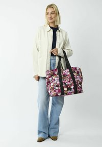 Tote bag in felroze met cartoonfiguren; stevige zwarte riemen; rechthoekige vorm; stofmateriaal; gestructureerd oppervlak met kleurrijke prints.