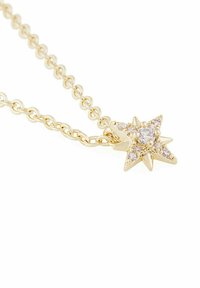 Guldhalsband med en stjärnformad hänge prydd med små klara stenar. Stjärnan har fem spetsar med texturerad dekoration.
