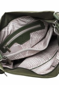 Interno di una borsa di tessuto verde con texture, dotato di più scomparti; foderato in beige con testo stampato; tasche con zip in colori a contrasto.