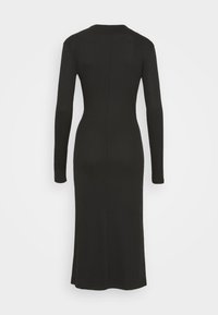 Abito nero in maglia a coste con maniche lunghe, scollo rotondo e silhouette aderente, che arriva fino a metà polpaccio.