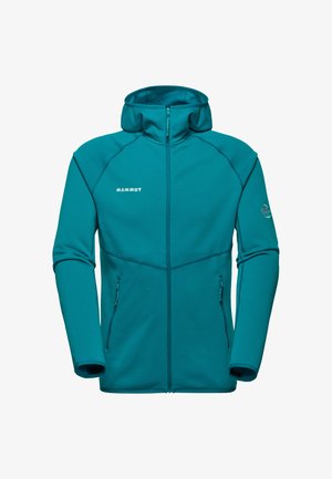 Felpa con zip color teal di Mammut, materiale morbido, colletto alto, due tasche laterali con zip, cuciture piatte e logo sul lato sinistro del petto. Design a maniche lunghe.