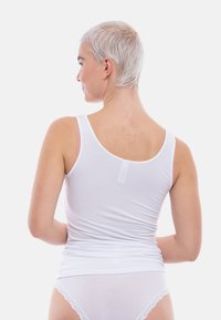 White, sleeveless tank top with a slim fit, made of lightweight fabric; features a smooth texture and a simple design.