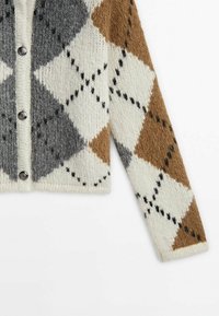 Manche et devant de cardigan boutonné avec motif losanges marron, gris et blanc sur tissu tricoté doux.