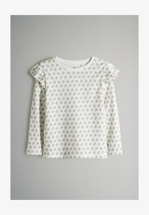 Biela detská košeľa s dlhými rukávmi a malým hnedým kvetinovým vzorom, s volánovými detailmi na pleciach, rozprestretá na svetlo šedom pozadí.