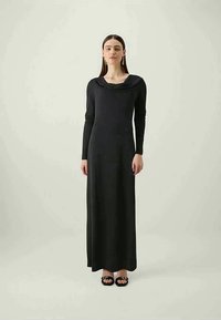 Vestido preto de mangas longas, até ao tornozelo, com decote drapeado. Feito de tecido suave, apresenta uma silhueta ajustada e um design minimalista.