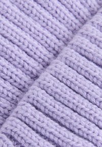 Lavendelgestrickter Stoff mit gerippter Textur. Die Fasern sind dick und weich, was ein gemütliches Erscheinungsbild mit einem leichten, luftigen Look erzeugt.