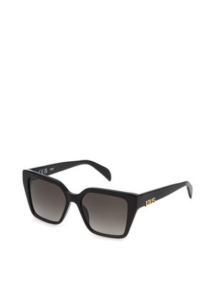 Lunettes de soleil carrées oversize noires avec verres dégradés foncés et logo doré "TOUS" sur les branches, vue en angle sur fond blanc.