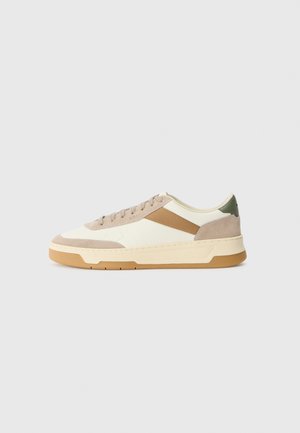 Baskets en beige, crème et vert olive, dotées de matériaux en daim et cuir, d'un bout rond, d'un design minimaliste et d'une semelle en caoutchouc.