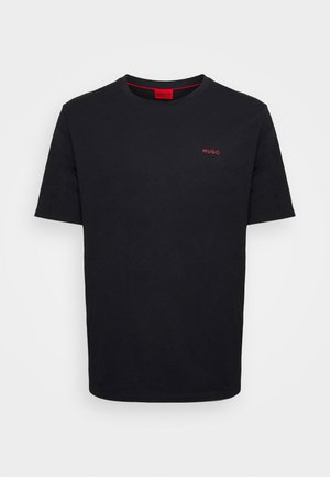 Camiseta negra de manga corta con cuello redondo, con pequeño logo rojo "HUGO" en el pecho izquierdo y etiqueta interior roja en el cuello.
