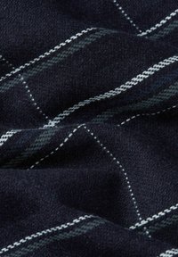 Wolstof met een donker marineblauwe achtergrond en afwisselend witte en grijze strepen, wat een geruit patroon creëert met een zachte textuur.