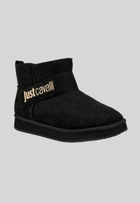 Stivaletto nero in suede con suola piatta e logo "justcavalli" dorato su una fascia testurizzata sul lato.