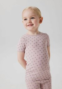 Krótki rękaw, jasnoróżowy komplet piżamy z fioletowym nadrukiem muszli. Miękka tkanina z koronkowym wykończeniem przy rękawach i dekolcie. Dobrze dopasowany.