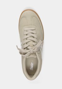 Baskets en daim beige avec des bandes blanches sur le côté, des lacets beige noués en nœud, et une semelle en caoutchouc gomme, vues de dessus sur un fond blanc.