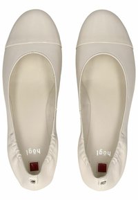 Beige Leder-Ballerinas mit rundem Zehenbereich und kontrastierender weißer Kappe. Das Innere ist glatt und hat einen kleinen roten Akzent an der Ferse.