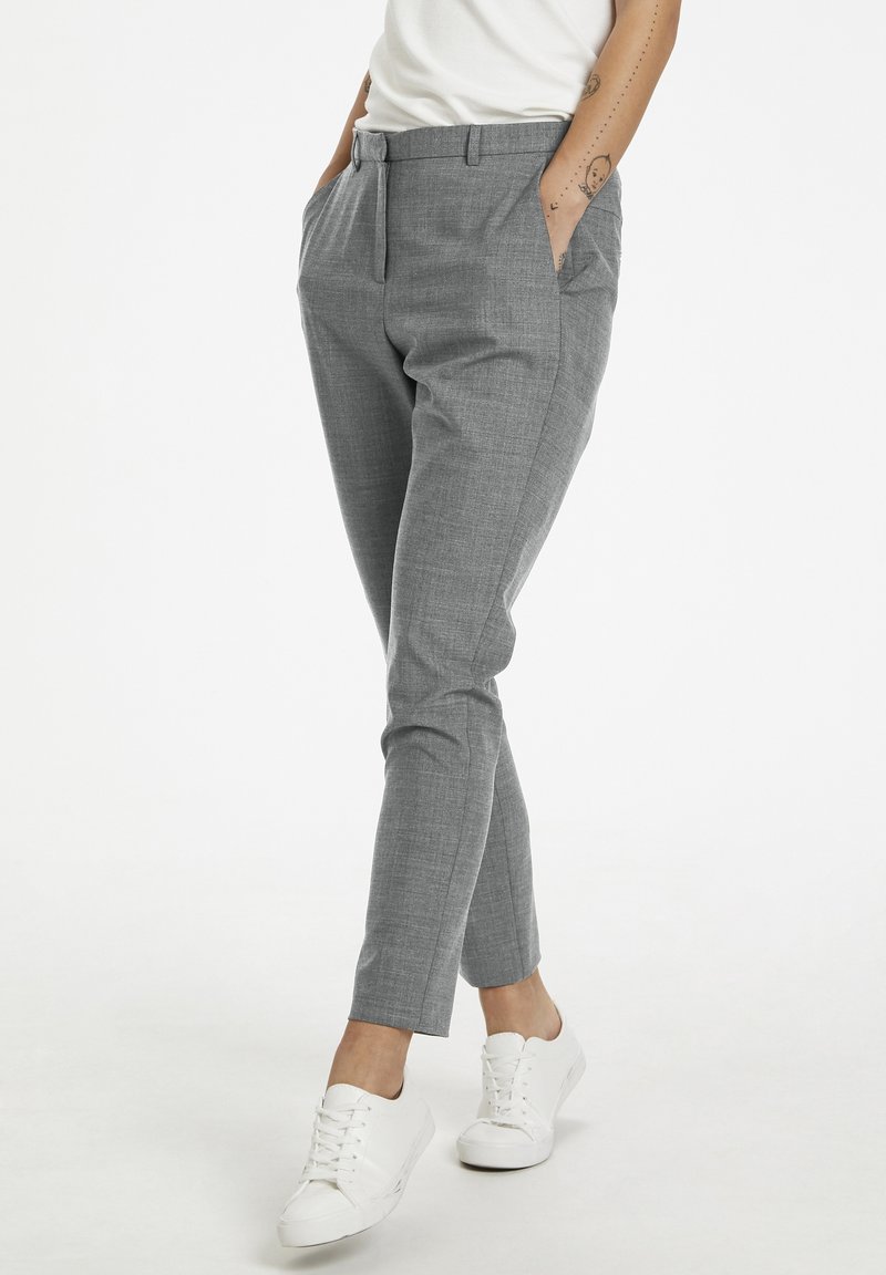 Grå, skräddarsydda byxor med ett strukturerat, vävt mönster, med sidofickor och smal passform, tillsammans med vita sneakers.