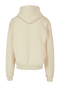 Sudadera con capucha color beige, de textura acanalada, diseño cropped y mangas largas. La vista trasera no muestra detalles ni patrones adicionales.