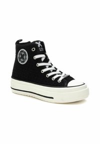 Sneaker alta nera con upper in tessuto texturizzato, punta in gomma bianca e suola spessa, dotata di occhielli e lacci argentati. Dettaglio rotondo del logo sul lato.