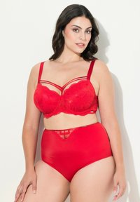 Rood lingerie set met een kant-bh met beugels en gedetailleerde patronen, gecombineerd met hoog verhoogde satijnen slips, beide met een gladde textuur.