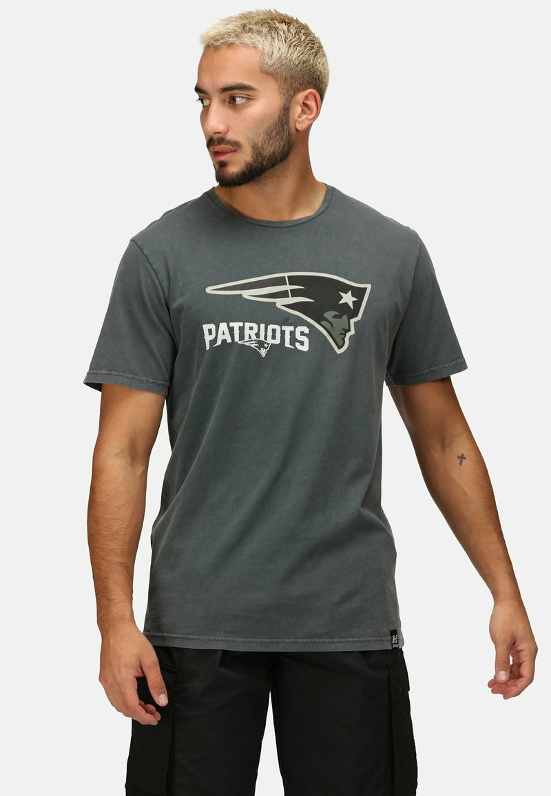 Šedé bavlněné tričko s logem "Patriots" v bílé a černé barvě, s kulatým výstřihem a krátkými rukávy. Volný střih, minimální textura.