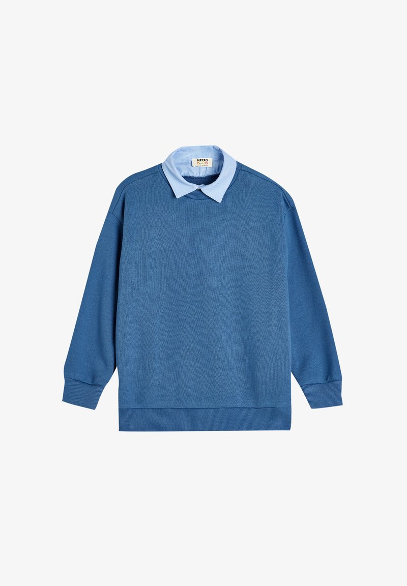 Maglione blu con una camicia col collarino azzurro sopra. Presenta maniche lunghe e un orlo a costine. Il materiale sembra morbido con un motivo testurizzato.