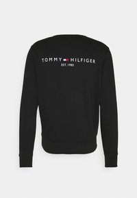 Felpa nera con polsini e orlo a coste, con scritta bianca "TOMMY HILFIGER EST. 1985" e un piccolo logo a blocco di colore sul retro.