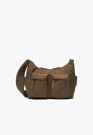 Braune Nylon-Umhängetasche mit breitem verstellbarem Riemen, zwei vorderen Reißverschlusstaschen und einem kleinen Markenpatch auf der unteren rechten Tasche.
