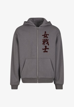 Graue Zip-up-Hoodie mit einem vorderen Reißverschluss, zwei Taschen, elastischen Bündchen und einem großen dunkelroten chinesischen Schriftzug-Design auf der linken Seite.