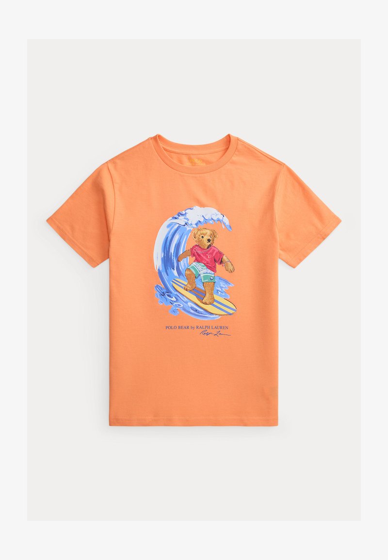 T-shirt orange à manches courtes avec un graphique d'ours surfant sur une vague et le texte « Polo Bear by Ralph Lauren » en dessous.