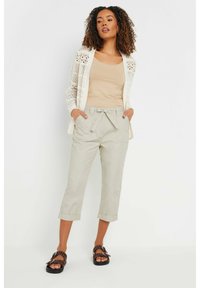 Lightweight crochet cardigan, beige tank top, light grey cropped pants with tie waist, and dark brown sandals with polka dots.