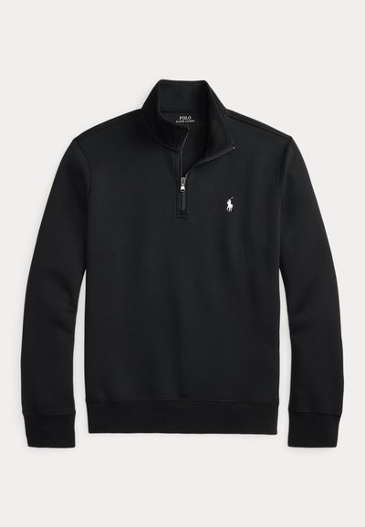 Svart genser i bomullsblanding. Har en glidelåslukking på kragen, ribbestrikkede mansjetter og nederkant, med en liten hvit logo på brystet.