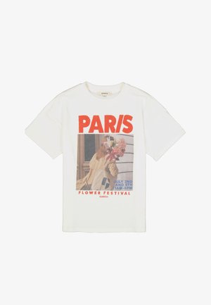 Camiseta blanca de algodón con estampado gráfico que incluye el texto "PARIS" y una imagen relacionada con un festival de flores. Mangas cortas, corte relajado.