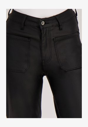 Zwarte hoog uitgesneden broek gemaakt van zachte stof. Voorzien van twee voorkanten zakken, zichtbare steken, en een enkele knoopsluiting.